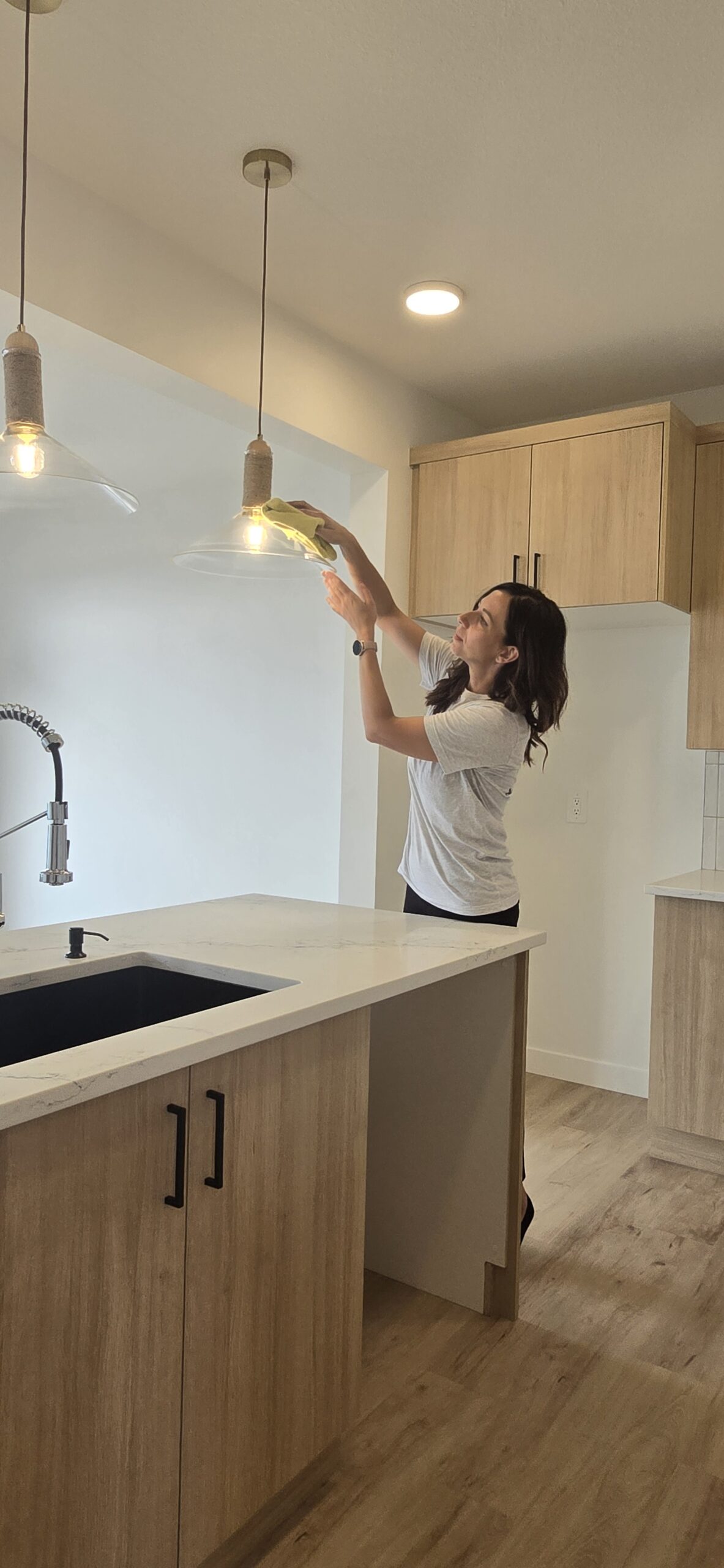 Taya detailing a light fixture during an Edmonton deep clean